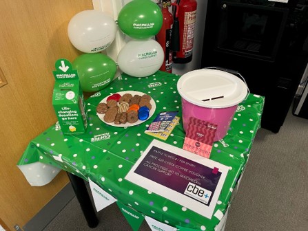 charity buckets on a coffee table with raffle tickets cakes and biscuits